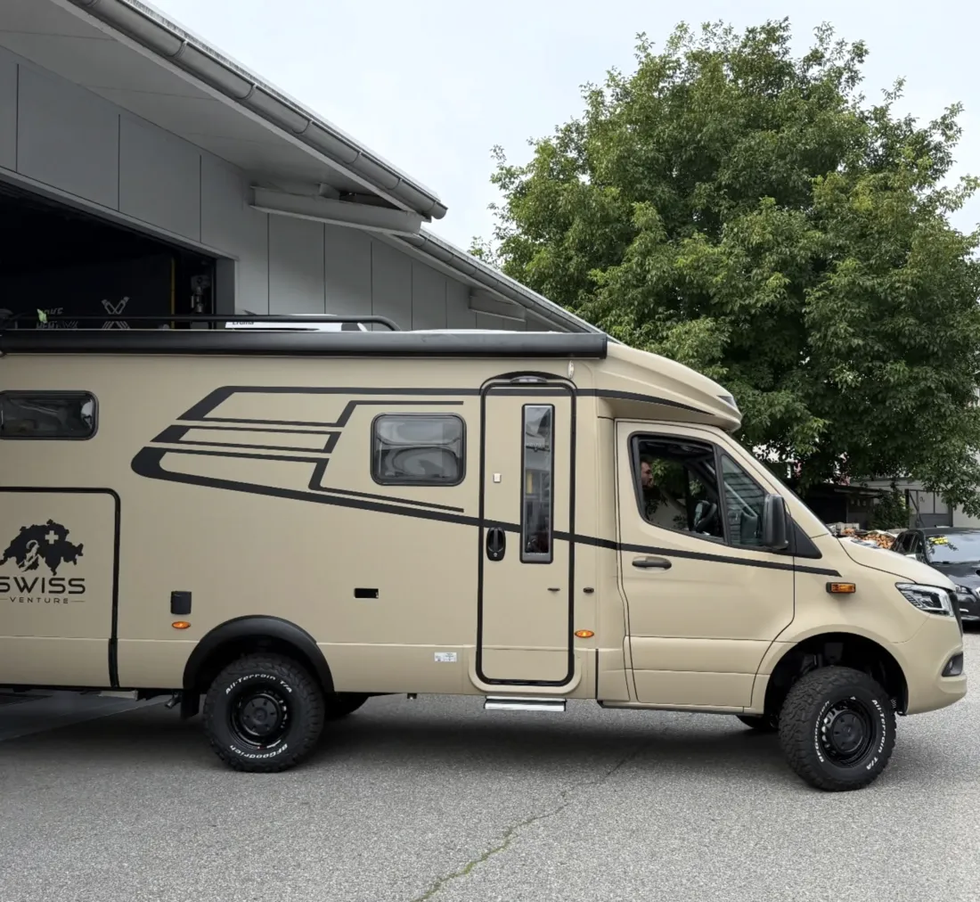 Sandfarbenes Swiss-Venture-4x4-Reisemobil in der Seitenansicht