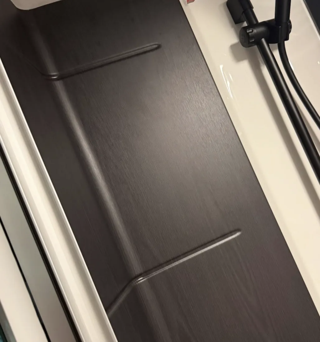 Detail einer Möbeldekor-Folierung in dunkler Holzoptik im Wohnmobil